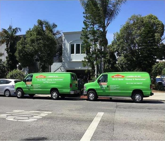 two green vans parked in front of a home